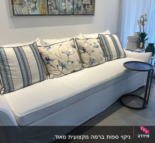 ספה לבנה עם כריות מעוצבות בחדר מגורים